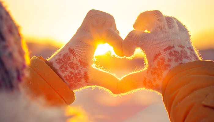 Woman hands in winter gloves Heart symbol