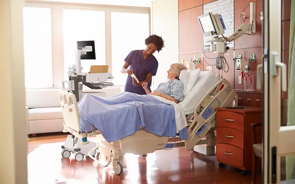 Doctor talking to patient on hospital bed.